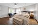 Bright bedroom showcasing a king bed, ceiling fan, two sitting chairs, and two windows for natural light at 470 Lakeview Shores Loop, Mooresville, NC 28117