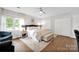 Bright bedroom showcasing a king bed, hardwood floors, with a ceiling fan, and two windows for natural light at 470 Lakeview Shores Loop, Mooresville, NC 28117