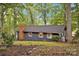 Exterior view of a charming home with a stone chimney, showcasing its cozy appeal nestled among the trees on the property at 470 Lakeview Shores Loop, Mooresville, NC 28117