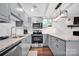 Modern kitchen with stainless steel appliances, gray cabinets, and granite countertops at 470 Lakeview Shores Loop, Mooresville, NC 28117