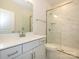 Modern bathroom with white marble tiled shower, gray cabinets, and bright lighting at 3228 Gavin Ln, Harrisburg, NC 28075