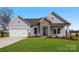 Charming single-story home featuring stone accents, a two-car garage, and a well-manicured lawn at 3228 Gavin Ln, Harrisburg, NC 28075