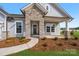 Inviting home featuring a stone porch and siding with manicured landscaping and a paved walkway at 3228 Gavin Ln, Harrisburg, NC 28075