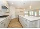 Bright kitchen features an island with seating, stainless steel appliances, and white cabinets and backsplash at 3228 Gavin Ln, Harrisburg, NC 28075