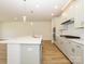 Bright kitchen features an island with seating, stainless steel appliances, and white cabinets and backsplash at 3228 Gavin Ln, Harrisburg, NC 28075