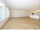 Open floor plan living room and kitchen area featuring bright white walls and light wood colored floors at 3228 Gavin Ln, Harrisburg, NC 28075