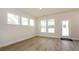Bright living room featuring hardwood floors, a modern door, and multiple windows at 3228 Gavin Ln, Harrisburg, NC 28075