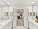 Dual vanity bath featuring double sinks, mirrors, and decorative artwork at 435 S Tryon St # 301, Charlotte, NC 28202