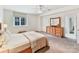 Comfortable bedroom features a large window, natural light, and a wooden dresser with a decorative mirror at 435 S Tryon St # 301, Charlotte, NC 28202