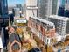 Aerial view of a residential building complex with brick facade, surrounded by lush greenery and city views at 435 S Tryon St # 301, Charlotte, NC 28202
