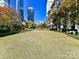Expansive community green space featuring manicured lawn, sculpture art, trees, and towering buildings at 435 S Tryon St # 301, Charlotte, NC 28202