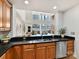 Modern kitchen featuring wooden cabinets, black countertops, stainless steel appliances, and an open layout with city views at 435 S Tryon St # 301, Charlotte, NC 28202