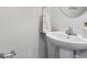 Bathroom with a white pedestal sink, chrome fixtures, and decorative towel accents at 5008 Winding Jordan Ln, Charlotte, NC 28269