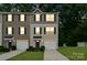 Well-maintained townhome exterior with two-car garage, manicured lawn, and classic architectural details for neighborhood charm at 5008 Winding Jordan Ln, Charlotte, NC 28269