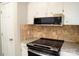 Kitchen features white cabinetry, stainless steel microwave and range, and a tiled backsplash at 525 12Th Sw St # 26, Hickory, NC 28602