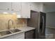 Well-lit kitchen featuring a stainless steel refrigerator, granite countertops, and tiled backsplash at 525 12Th Sw St # 26, Hickory, NC 28602