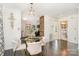 Bright dining area features a glass table, seating for four, decorative lighting, and access to the kitchen and bathroom at 630 S Myrtle School Rd, Gastonia, NC 28052