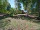 A home backyard featuring lush lawn, mature trees and deck in background at 907 Weymouth Dr, Gastonia, NC 28056