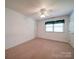 Bright bedroom with neutral carpet, ceiling fan, and a window providing natural light at 907 Weymouth Dr, Gastonia, NC 28056