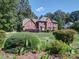 Two-story brick home featuring a landscaped front yard and mature trees at 907 Weymouth Dr, Gastonia, NC 28056