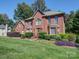A brick home with a manicured lawn showcases its front facade with large windows and a classic entrance at 907 Weymouth Dr, Gastonia, NC 28056