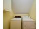 Functional laundry area with a washer and dryer, and upper cabinets for storage at 907 Weymouth Dr, Gastonia, NC 28056