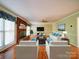 Bright living room with a brick fireplace, white furniture, and hardwood floors at 907 Weymouth Dr, Gastonia, NC 28056
