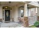 Inviting front porch with stone columns and wicker chair at 3150 Helmsley Ct, Concord, NC 28027