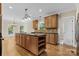 Kitchen with an island, wood cabinets, granite countertops, and stainless steel appliances at 4800 Pimlico Ln, Waxhaw, NC 28173