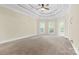 Main bedroom with tray ceiling, carpet, and access to the bathroom at 4800 Pimlico Ln, Waxhaw, NC 28173