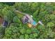 An aerial view of the home surrounded by lush greenery, featuring a private pool and a long driveway at 10604 Russet Pl, Charlotte, NC 28227