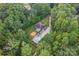 Aerial view of home surrounded by mature trees, featuring an in-ground pool, patio and long driveway at 10604 Russet Pl, Charlotte, NC 28227