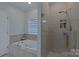 Bathroom featuring a soaking tub and glass-enclosed shower with tiled surround at 10604 Russet Pl, Charlotte, NC 28227