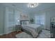 Cozy bedroom with a large bed, gray carpet, decorative lighting, and windows at 10604 Russet Pl, Charlotte, NC 28227