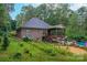 Brick home featuring a covered porch, sprawling backyard, and inviting pool area, set amidst lush greenery at 10604 Russet Pl, Charlotte, NC 28227