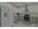 Well-lit kitchen with white and gray cabinets, stainless steel appliances, and a sleek range hood at 10604 Russet Pl, Charlotte, NC 28227