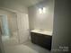 Modern bathroom features a stylish vanity with sleek countertop and contemporary fixtures and an open doorway to the tub at 8605 Carly Ln, Mint Hill, NC 28227