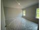 Well-lit bedroom with neutral walls and floors covered in protective plastic at 8605 Carly Ln, Mint Hill, NC 28227
