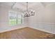 Elegant dining room with modern chandelier, wainscoting, and bright window at 8605 Carly Ln, Mint Hill, NC 28227