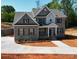 Stunning two-story brick home featuring a manicured lawn, complemented by dark shutters and a concrete driveway at 8605 Carly Ln, Mint Hill, NC 28227