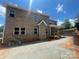 Two-story brick house with a covered patio overlooking a well-designed yard perfect for enjoying outdoor gatherings at 8605 Carly Ln, Mint Hill, NC 28227