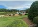 Picturesque gazebo overlooking a serene pond with a fountain, surrounded by manicured gardens and lush greenery at 8605 Carly Ln, Mint Hill, NC 28227