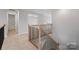 Hallway with oak handrails, black metal balusters, and neutral carpet at 8605 Carly Ln, Mint Hill, NC 28227