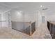 Hallway featuring oak railing with black iron spindles, and neutral carpet at 8605 Carly Ln, Mint Hill, NC 28227