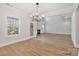 Bright open-concept living space with hardwood floors, a fireplace, and a modern chandelier fixture at 8605 Carly Ln, Mint Hill, NC 28227