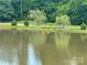 Scenic pond featuring benches by the walkway surrounded by mature trees and greenery at 8605 Carly Ln, Mint Hill, NC 28227