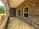 Charming porch showcasing brick walls and wooden deck flooring at 8605 Carly Ln, Mint Hill, NC 28227
