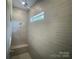 Modern shower with gray tiling, a built-in bench, and a window at 8605 Carly Ln, Mint Hill, NC 28227