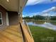 Spacious back porch with wood flooring and a scenic view of the water and greenery at 9411 Stonebridge Way # 49, Mint Hill, NC 28227