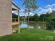 The backyard features a large pond, lush green grass, and mature trees at 9411 Stonebridge Way # 49, Mint Hill, NC 28227
